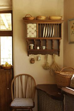 a wooden chair sitting next to a shelf filled with dishes