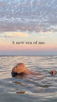 a woman floating in the ocean with her head above water and an inscription that reads, a new era of me