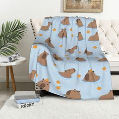 a blanket with bears on it sitting in front of a couch