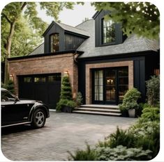 a black car is parked in front of a brick house with large windows and doors