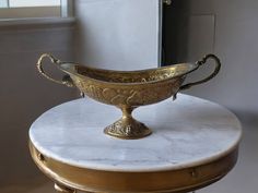 a large metal bowl sitting on top of a marble table