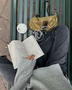 a person sitting on a bench reading a book