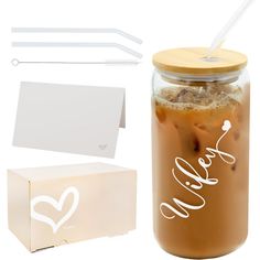 a glass jar filled with liquid next to a cardboard box and two drinking straws