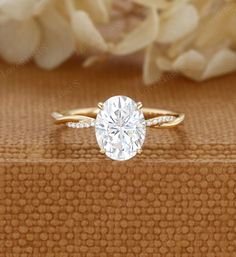 a close up of a ring with a flower in the background