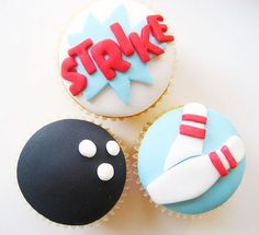 three decorated cupcakes sitting next to each other on top of a white table