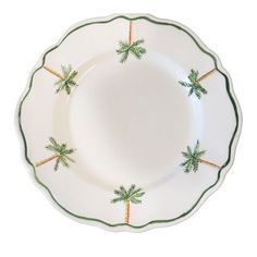 a white plate with green trim and palm trees on the rim, against a white background