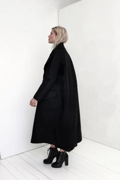 "Premium quality Black woolen coat has an oversize silhouette through the body , crafted in a heavy and thick high quality Italian wool fabric. Calf-length coat is fastened with two knobs. The coat has a unique cut , features big collar, long sleeves and is very stylish. This coat has a horizontal line through the front and back, there are large pockets in front. On one side on the shoulder is a decorative detail. The coat is with viscose lined. This coat is very stylish and unique created by a Black Oversized Long Outerwear, Oversized Long Black Outerwear, Black Long Oversized Outerwear, Black Long Wool Coat For Winter, Oversized Long Wool Coat For Winter, Oversized Long Wool Coat For Work, Chic Long Black Wool Coat, Black Wool Long Sweater Coat, Black Oversized Long Sleeve Pea Coat