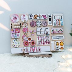 a wooden board covered in lots of magnets and stickers next to a potted plant