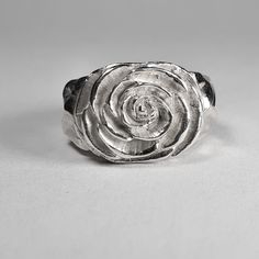 **Please note that we dispatch on Tuesdays unless special delivery express option is paid for** Sterling silver Camellia ring. Original design carved in wax then lost wax cast into solid sterling silver.  Piece weighs approximately 17g.  Shown in a size N, and adjustable to ring sizes I-S.  A significant size adjustment may alter the appearance slightly.  First class post included, with a supplement for special delivery. Carved Silver Ring, Sterling Silver Carved Promise Ring, Carved Sterling Silver Rings For Anniversary, Anniversary Sterling Silver Carved Rings, Anniversary Carved Sterling Silver Ring, Silver Carved Sterling Silver Signet Ring, Silver Carved Signet Ring For Wedding, Unique Hand Cast Sterling Silver Engraved Ring, Silver Carved Engraved Ring For Anniversary