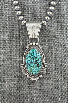 This natural Kingman turquoise and brushed-finish sterling silver necklace was made by Navajo silversmith Tom Lewis. The top of the bail is signed Tom Lewis and stamped sterling.Necklace: 18"Bead size: 1/4" x 1/4"Pendant Length: 2 7/8"Pendant Width: 1 1/4"Free shipping on all orders! We ship with USPS and always include tracking. All orders ship within a day of payment.Returns are accepted up to 30 days after you receive your order. Just send us a message. Our shop offers cash back or store credit. The item must be returned in new condition. Southwestern Style Engraved Turquoise Necklaces, Silver Turquoise Pendant Necklace With Patina, Silver Pendant Turquoise Necklace With Patina, Southwestern Silver Necklace With Patina, Collectible Sterling Silver Turquoise Necklace With Patina, Southwestern Engraved Turquoise Necklace In Sterling Silver, Sterling Silver Turquoise Necklace With Patina, Tom Lewis, Sterling Necklace