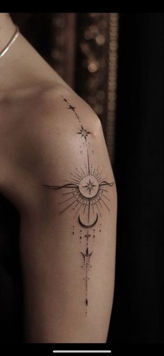 a woman's arm with a sun and stars tattoo on the left side of her shoulder