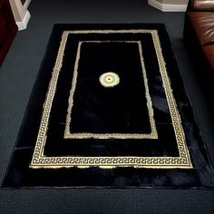 a black area rug with gold trimmings and a medallion on the center piece