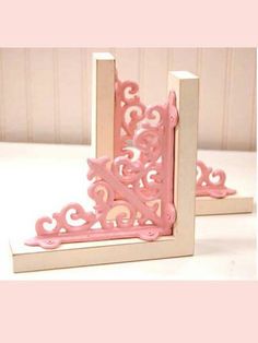 two pink and white bookends sitting next to each other on top of a table