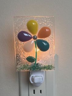 a light that is on the side of a wall with a flower inside of it