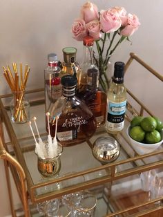 the bar cart is filled with alcohol and cocktails