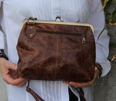 Brown scrunchy top clip clasp cross body adjustable handbag purse Bygone era handbag with long adjustable strap, Front zip for phone, internal pockets for organisation and a lot of charm! 26 x 17 frame 23 x 29 dimensions of bag Base 27 x 6 Front pocket 15 x 15 Internal pocket 10 x 13.5 Internal pocket zipped 19 x 17 Strap 68 x 2 and 2cms wide Vintage Shoulder Bag With Fold Over Clasp, Vintage Bag With Fold Over Clasp For Everyday Use, Chic Purses, Cross Body Purse, Bygone Era, Distressed Leather, Retro Chic, Handbag Purse, Purses Crossbody