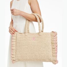 This beach-ready oversized tote, crafted from unlined twisted raffia, is a must-have on sunny days. The durable, structured handle, tassel accessory and playful handcrafted ruffled edging make it stand out, at the shore, by the pool or anywhere you need ample storage for long summer days. A monogram adds a personal touch.    17"w x 4"d x 13"h  Handle drop: 8"  Paper straw and twisted raffia.  Spot clean and store only when completely dry.  Made in India.  Monogramming is embroidered. Chic Straw Bag With Tassels, Spring Rectangular Straw Bag With Tassels, Spring Vacation Bag With Fringe Details, Chic Summer Beach Bag With Fringe, Chic Fringed Beach Bag For Vacation, Chic Fringe Beach Bag For Summer, Chic Fringe Beach Bag For Vacation, Chic Natural Straw Bag With Fringe, Chic Fringe Beach Bag