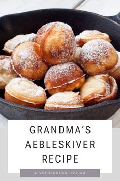 a pan filled with powdered sugar covered pastries on top of a wooden table