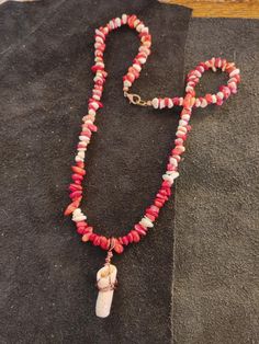 a beaded necklace with an animal's head on it and a long chain