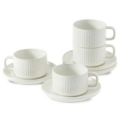 three white cups and saucers with wavy designs