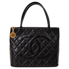 Chanel Black Lambskin Quilted Medallion Tote Gold Hardware 100% Authentic   This stylish tote is beautifully crafted of diamond-quilted lambskin leather in black with a prominent Chanel CC logo patch on the front. The bag features a rear patch pocket and rolled leather top handles. The gold zipper pull opens the bag to a smooth black leather interior with zipper and patch pockets. Base length: 11.75 in Height: 9.50 in Width: 6.00 in Drop: 6.25 in Excellent Condition CDT529187 NM7.30.24 One of the most famous fashion and handbag designers of all time, Gabrielle Bonheur "Coco” Chanel opened her first millinery on Paris’s Rue Cambon in 1910. By 1920, Chanel had ventured into apparel, while the 1930s brought the first release of the Chanel handbag. 1920 Chanel, French Tote Bag, Vintage Chanel Bag, Chanel Brand, Chanel Tote, Novelty Bags, Handbag Heaven, Classic Bags, Famous Fashion