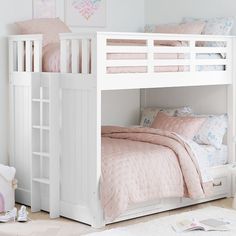 a white bunk bed with pink comforter and pillows on the bottom level, in a girls bedroom