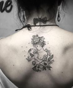 the back of a woman's shoulder with flowers and a lady holding a bird