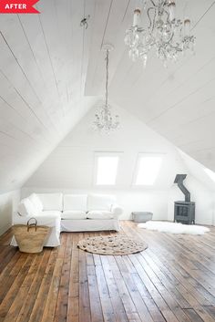 a white couch sitting on top of a wooden floor next to a chandelier