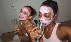 two women with pink facial masks on their faces holding champagne glasses and looking at the camera