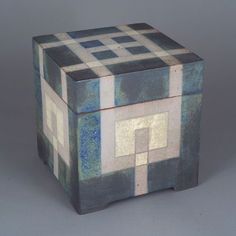 a blue and white box sitting on top of a gray table next to a wall