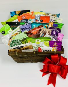 a basket filled with lots of different types of snacks and candy bar wrapped in red ribbon