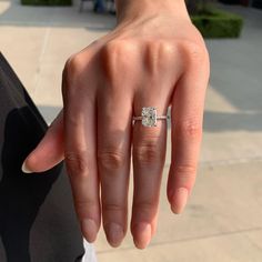 a woman's hand with a diamond ring on it