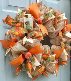 an orange and white wreath on the front door is decorated with burlucks