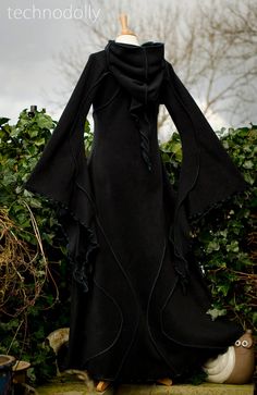 ~ Haunted Hawtin Cloak ~ Made to Measure ~ The floor length Haunted Hawtin Cloak is a simple & beautiful design. Made using soft fleece fabric with elegant trim detail to create a delicate flowing line of colour & form. It is floor length with large medieval flared sleeves, a open front with a single clasp fastening at the throat & pixie hood. *From Petite Pixies to Rubenesque Goddesses. Whatever shape you take I can accommodate* COLOURS ~ If none of the colours offered tickles your Medieval Long Sleeve Outerwear For Alternative Fashion, Medieval Long Coat For Halloween, Medieval Style Outerwear For Halloween, Gothic Outerwear For Fantasy Events In Winter, Black Fitted Medieval Outerwear, Gothic Outerwear For Fantasy Events In Fall, Gothic Outerwear For Fall Fantasy Events, Gothic Black Outerwear For Larp, Black Medieval Long Sleeve Outerwear