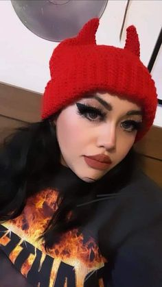 a woman with long black hair wearing a red knitted cat ear beanie hat