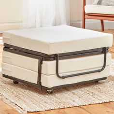 a white ottoman sitting on top of a wooden floor