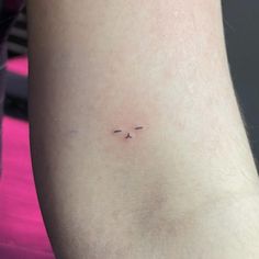 a small tattoo on the leg of a person's left arm, with an arrow