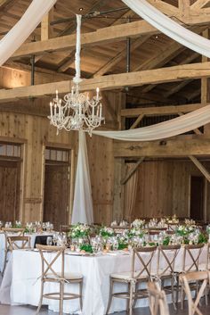 the tables are set with white linens and greenery for an elegant wedding reception