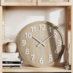 a clock sitting on top of a book shelf next to a vase and some books