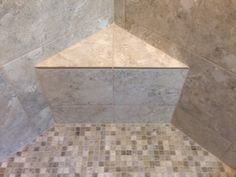 a tiled shower stall in a bathroom with beige and white tiles on the floor, walls and ceiling