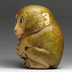 a figurine of a monkey sitting on its hind legs