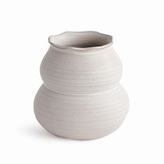 a white vase sitting on top of a table