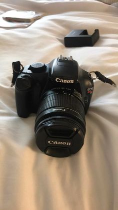 a camera sitting on top of a white bed