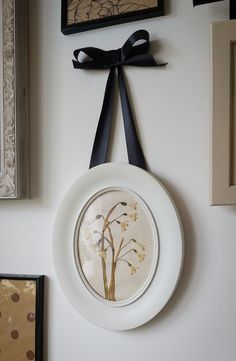 a white plate with a black ribbon hanging on the wall