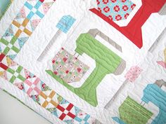 a quilted table topper with many different designs on it, including an oven