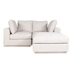 a white sectional couch with pillows on it's back and the seat folded out