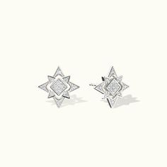 pair of earrings with diamonds in the shape of an ornament on white background