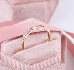 an open ring sitting on top of a pink box