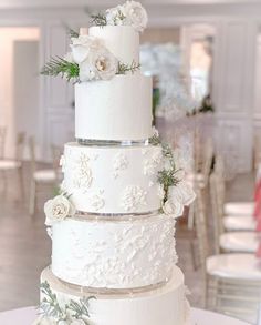 a wedding cake with white flowers and greenery