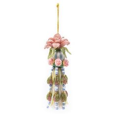 an ornament with flowers hanging from it's side on a white background